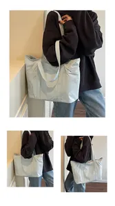 Close-up of a large light blue nylon tote bag with side pockets and durable shoulder straps