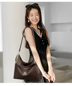 Detail der dunkelbraunen Hobo-Tasche aus Leder mit goldener Hardware und Kette