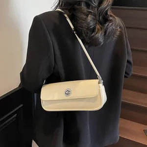 Schicke beige Lackleder Baguette Schultertasche mit Silber Verschluss auf schwarzem Anzug