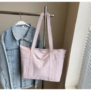 Detail view of the front double pockets on light purple nylon tote bag for women