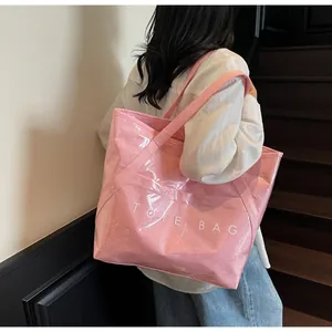 Detail der pinkfarbenen Shoppingtasche mit TOTE BAG Aufdruck an der Schulter des Models