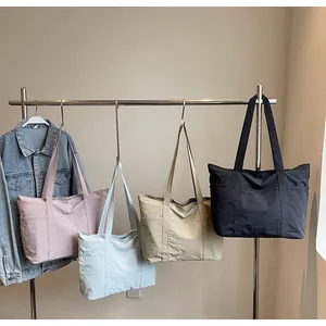 Detail of four colorful nylon tote bags with wide shoulder straps and side pockets