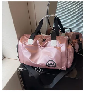 Detalle de bolsa de deporte rosa metalizada con asas resistentes y bolsillo lateral