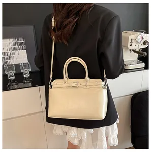 Sac à main chic de couleur crème avec poignées rondes et boucle en métal, décor moderne