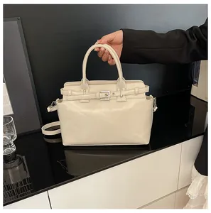 Détail d'un sac à main crème avec boucle argentée et bandoulière réglable