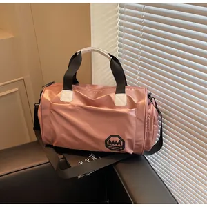 Detalle de bolsa de deporte impermeable en oro rosa con correas negras y bolsillo lateral