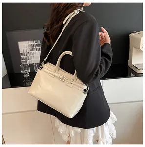 Détail d'un sac bandoulière en cuir blanc crème montrant la sangle et les boucles