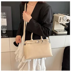 Sac bandoulière rectangulaire beige avec boucle dans un cadre de trajet élégant