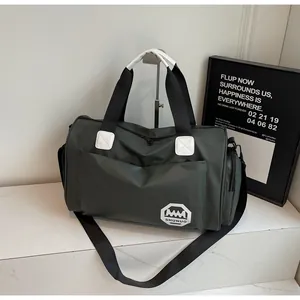 Detalle de bolsa de viaje verde oscuro con asas negras y herrajes metálicos resistentes
