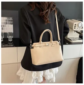 Sac à bandoulière beige chic porté par un mannequin dans un cadre intérieur moderne