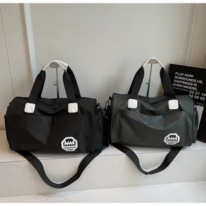 Detalle de bolsas de viaje grandes e impermeables en negro y verde oliva con el logotipo