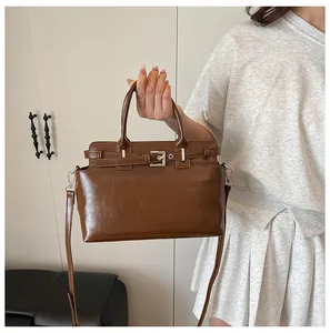Détail du sac à main marron avec boucle argentée et bandoulière réglable amovible