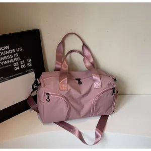 Detail of rose pink nylon travel bag with front zip pockets and detachable shoulder strap
