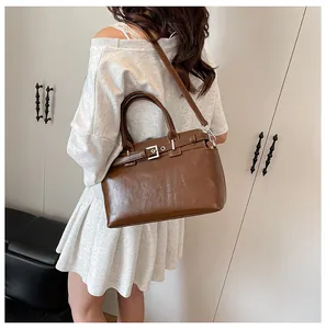 Gros plan du sac bandoulière en cuir marron montrant le profil latéral et la sangle