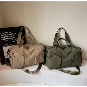 Detail view of khaki and olive green nylon travel bags with multiple zippered pockets