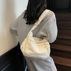 Retro multi-pocket cream canvas crossbody bag shown on model in a casual stylish setting
