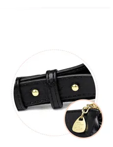 Macro view of black litchi leather strap and golden drop-shaped zipper with kangaroo logo