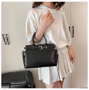 Détail du sac cabas en similicuir noir avec boucle argentée et bandoulière réglable