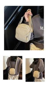 Detailansicht der minimalistischen beigen Nylon-Umhängetasche mit Doppel-Reißverschluss