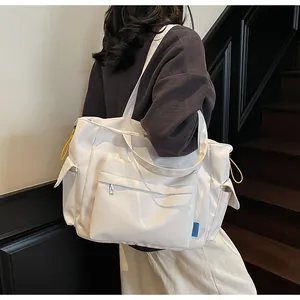 Detail of white large capacity tote bag with functional pockets and side drawstrings