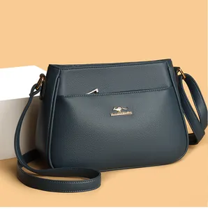 Detail of navy blue pebble leather shoulder bag with gold hardware and kangaroo logo