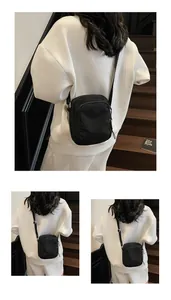 Details der schwarzen Nylon-Handytasche mit Doppelreißverschluss und Schultergurt