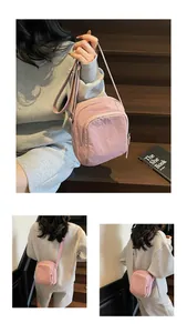 Detailansicht der pinken Nylon-Umhängetasche mit Doppelreißverschluss und Gurtband
