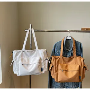 Detail view of large canvas tote bags with multiple pockets in cream and camel colors
