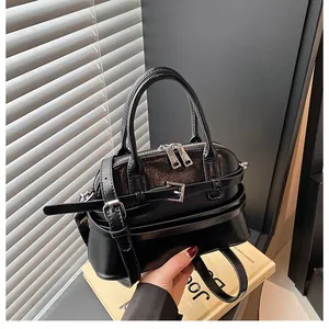 Macro shot of glossy black wrinkled patent leather texture and silver zipper of the handbag