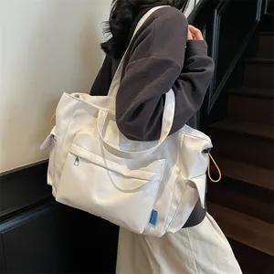 Large white nylon crossbody tote bag with multi-pocket design and yellow drawstrings