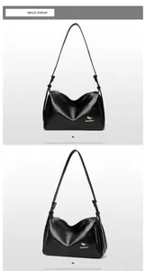 Detailed macro view showing the glossy black leather texture and gold kangaroo logo on the bag