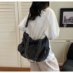 Detail der schwarzen Denim-Tasche mit Stern-Applikation und runder Münzbörse