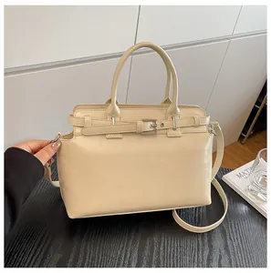 Détail du sac à main en cuir crème avec anneaux argentés et ceinture à boucle décorative