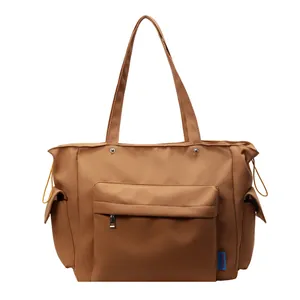 Brown nylon tote bag with multiple pockets and drawstring sides for casual daily use