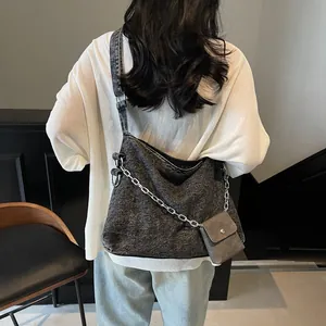 Large gray denim tote bag with silver chain and mini pouch on adjustable strap