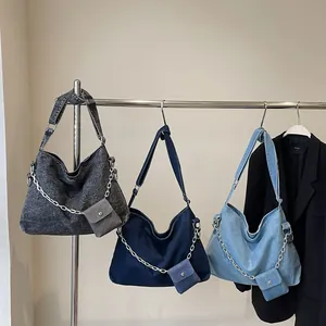 Denim tote bag with large capacity, wide strap crossbody style, and mini pouch charm