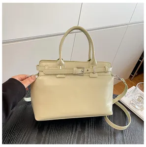 Détail d'un sac à main en cuir PU vert clair avec boucle argentée et bandoulière amovible