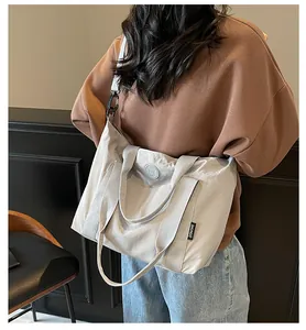 Détail du grand sac cabas gris clair en nylon avec bandoulière et étiquette latérale