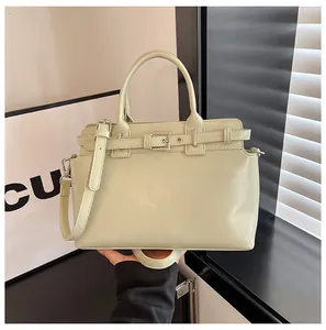 Détail du sac à main vert menthe en similicuir avec boucle argentée et deux poignées