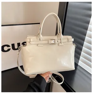 Gros plan du sac carré crème montrant la texture fine et le détail de la boucle en métal