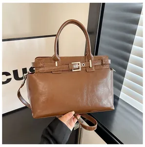 Détail du sac en cuir PU marron avec ferrures argentées et doubles poignées de main