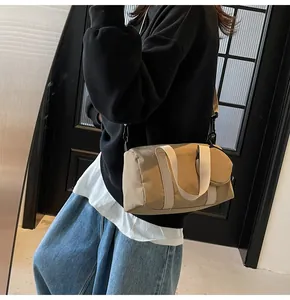 Détails du sac cylindrique en toile kaki avec bandoulière et petit porte-monnaie rond