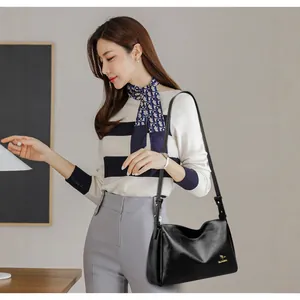 Classic black leather Boston bag with gold kangaroo logo and adjustable crossbody strap