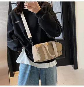 Détail du sac cylindre en toile kaki avec petite pochette ronde et bandoulière amovible