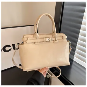 Détail d'un sac à main en cuir blanc cassé avec boucle en métal et bandoulière amovible
