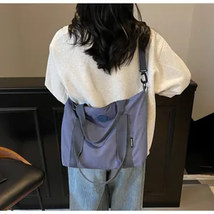 Détail du grand sac cabas bleu avec bandoulière réglable porté par un mannequin