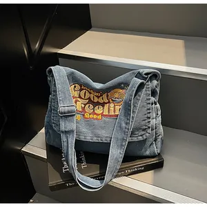 Macro view of washed denim fabric with vibrant yellow embroidery on the shoulder bag