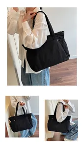 Drieluik van een grote zwarte tote bag met schouderband en geplooide zijden details