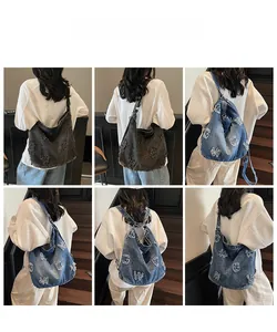 Detail showing oversized denim tote with frayed letter patchwork on casual shoulder bag