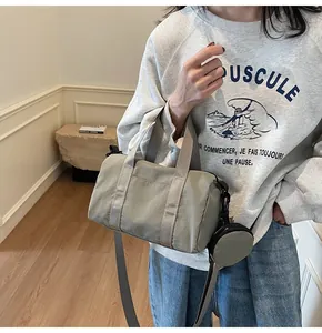 Détail du sac cylindre en nylon gris-vert avec sangle et petit porte-monnaie